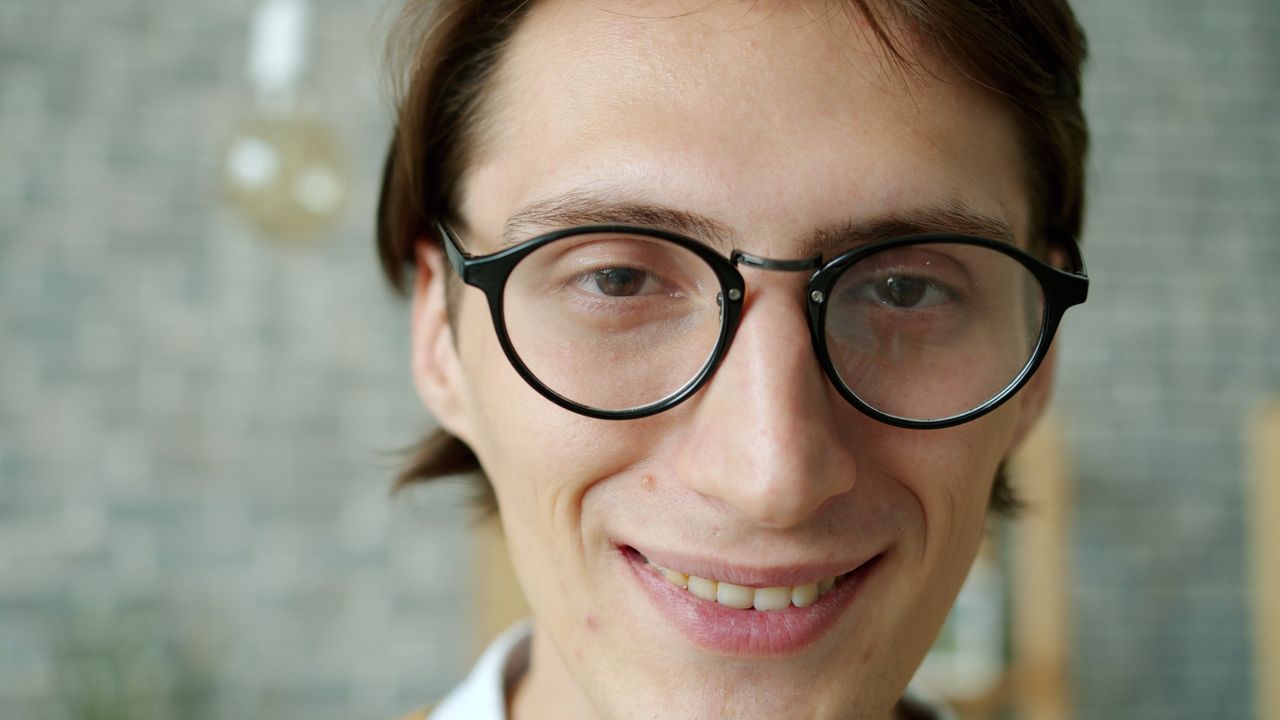 A person with a square face shape wearing glasses