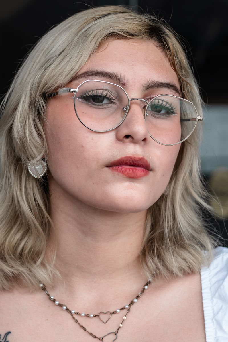 A person with a round face shape wearing glasses